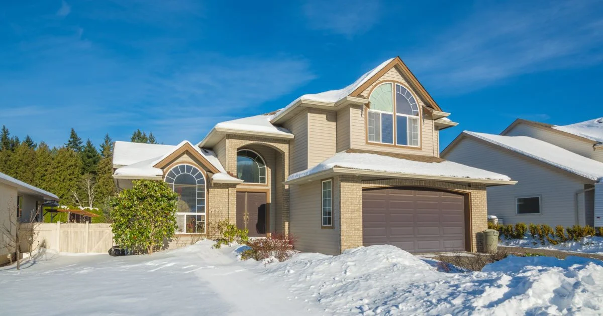 Residential home with garage door in winter snow